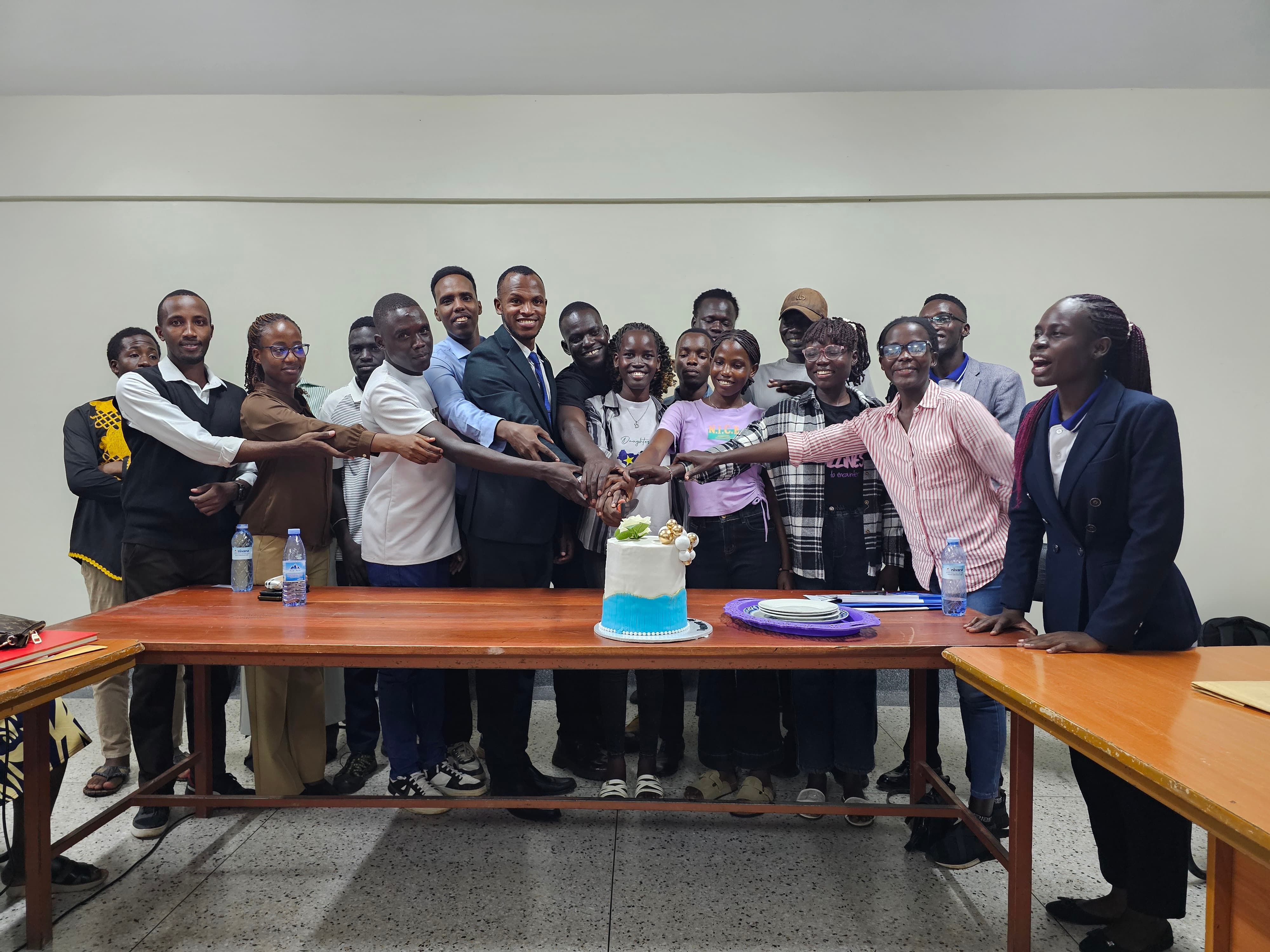 International students and other participants share a cake-cutting moment during the third International Students’ Orientation at Namasagali Campus on 18 October 2026.