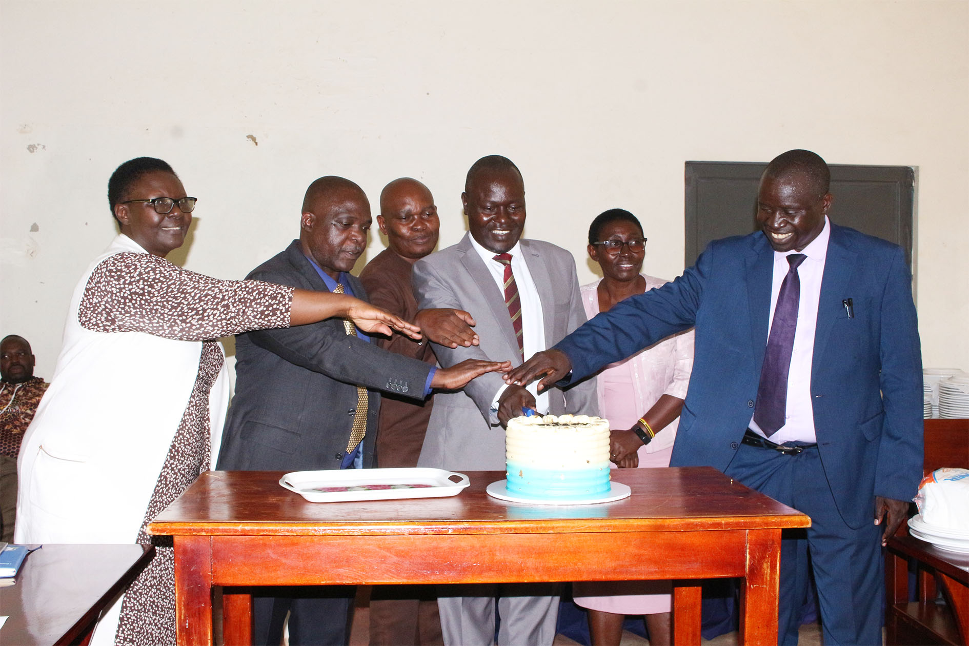 Top Management together with the outgoing and incoming Deans cut a cake to mark the official handover ceremony